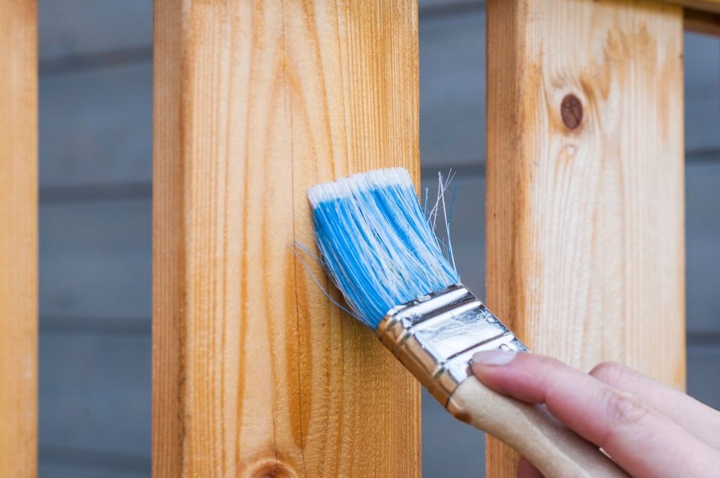 Brush applying finish to bare wood