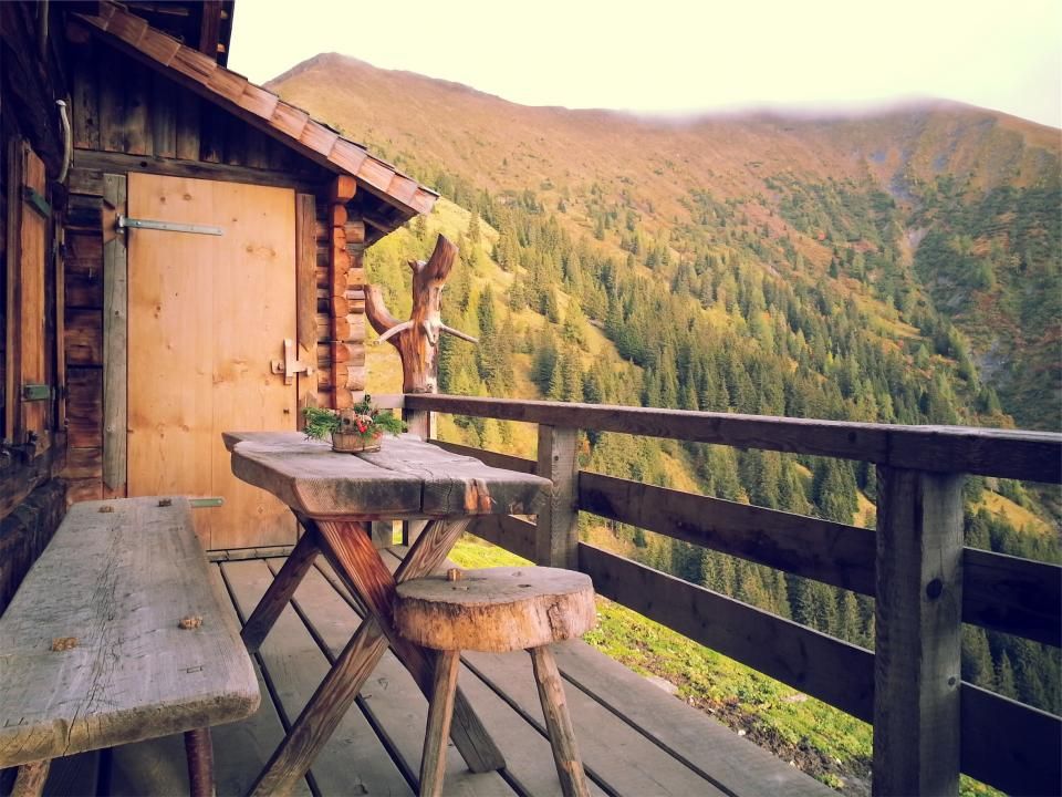 Wood deck and railing on a cabin overlooking a wooded mountain