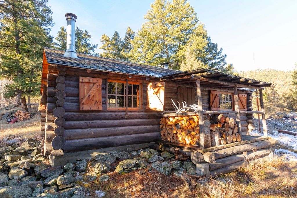 Log cabin with a covered porch and stacked firewood